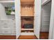 A closet with white cabinets and drawers, wood floors, and a TV on the wall at 805 Johnson Ave, Lakeland, FL 33801