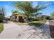 Bungalow-style home with a well-manicured lawn, mature trees, and a long driveway at 805 Johnson Ave, Lakeland, FL 33801