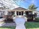 Inviting bungalow-style home with a screened front porch, manicured landscaping, and a paver walkway at 805 Johnson Ave, Lakeland, FL 33801