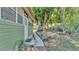 Landscaped backyard featuring a stone bench, mature trees, and potted plants along a brick walkway at 822 W Patterson St, Lakeland, FL 33803
