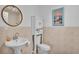 Bathroom features a toilet, pedestal sink, framed round mirror and a cabinet for storage at 822 W Patterson St, Lakeland, FL 33803