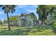 Side view of a green two-story home featuring a covered wrap-around porch and lush landscaping at 822 W Patterson St, Lakeland, FL 33803