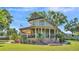 Two-story home featuring a sprawling wrap-around porch, lush landscaping, and manicured lawn at 822 W Patterson St, Lakeland, FL 33803