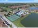 Extensive aerial view of the community pool, lake, basketball court, and tennis courts at 8931 Sugar Palm Rd, Kissimmee, FL 34747