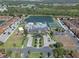This aerial shot features a resort-style pool, clubhouse, tennis courts, and a lake surrounded by lush landscaping at 8931 Sugar Palm Rd, Kissimmee, FL 34747