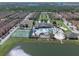 A beautiful aerial view of the community featuring a clubhouse, swimming pool, tennis courts, and lush landscaping near a lake at 8931 Sugar Palm Rd, Kissimmee, FL 34747