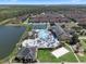 Aerial view features a community pool, clubhouse, beach volleyball court, playground, lake, and townhome residences with green space at 8931 Sugar Palm Rd, Kissimmee, FL 34747