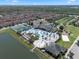 This aerial shot showcases the community amenities, including a pool, clubhouse, and tennis courts, surrounded by residences and greenery at 8931 Sugar Palm Rd, Kissimmee, FL 34747