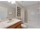 Bathroom featuring vanity with a single sink, shower-tub combo with white tiling, and a toilet at 8931 Sugar Palm Rd, Kissimmee, FL 34747
