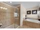 Bright bathroom featuring a soaking tub, tiled shower, and neutral decor for a serene atmosphere at 8931 Sugar Palm Rd, Kissimmee, FL 34747