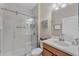 Bright bathroom with a glass shower, white walls and a wood cabinet at 8931 Sugar Palm Rd, Kissimmee, FL 34747