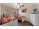 Inviting bedroom featuring themed decor, hardwood floors, a ceiling fan, and a TV at 8931 Sugar Palm Rd, Kissimmee, FL 34747