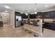Spacious kitchen boasts dark cabinetry, stainless steel appliances, granite countertops, and a central island at 8931 Sugar Palm Rd, Kissimmee, FL 34747