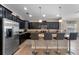 Well-appointed kitchen with dark cabinets, granite counters, stainless appliances, and island with barstools at 8931 Sugar Palm Rd, Kissimmee, FL 34747