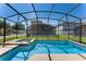 Enclosed pool and spa featuring a clear blue sky and greenery at 8931 Sugar Palm Rd, Kissimmee, FL 34747