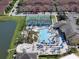 An aerial view of the pool featuring a water slide, sun loungers, and lush landscaping; tennis court is also visible at 8931 Sugar Palm Rd, Kissimmee, FL 34747