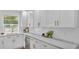 Bright kitchen featuring white cabinets, subway tile backsplash, quartz countertops, and gold hardware at 919 S Missouri Ave, Lakeland, FL 33803