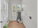 Bright laundry room with a water heater, hardwood floors, and white horizontal blinds at 919 S Missouri Ave, Lakeland, FL 33803
