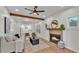 Bright living room featuring modern ceiling fan, a fireplace, and wooden beam accents at 919 S Missouri Ave, Lakeland, FL 33803