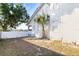 Side yard featuring a grassy area, palm trees, white privacy fence, and views of the neighborhood at 934 Lake Elbert Se Dr, Winter Haven, FL 33880
