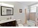Bathroom with vanity, toilet, tiled shower with a shower curtain and window at 934 Lake Elbert Se Dr, Winter Haven, FL 33880