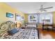 Sunny bedroom featuring two beds with metal frames, wood floors, and bright natural light at 934 Lake Elbert Se Dr, Winter Haven, FL 33880
