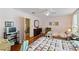Bright bedroom featuring two beds, hardwood floors, a TV, and vintage decor elements at 934 Lake Elbert Se Dr, Winter Haven, FL 33880