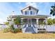 Charming home featuring a large, screened-in front porch and well-manicured landscaping at 934 Lake Elbert Se Dr, Winter Haven, FL 33880