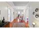 Long hallway with hardwood floors and vintage decor leading to other rooms in the home at 934 Lake Elbert Se Dr, Winter Haven, FL 33880