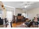 Bright living room with hardwood floors, brick fireplace, large windows, and a ceiling fan at 934 Lake Elbert Se Dr, Winter Haven, FL 33880