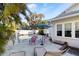 Outdoor pool area featuring lounge chairs, dining set, lush landscaping, and a white privacy fence at 934 Lake Elbert Se Dr, Winter Haven, FL 33880