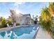 Inviting pool area featuring a sparkling pool surrounded by lush tropical landscaping, lounge chairs, and sun-drenched patio at 934 Lake Elbert Se Dr, Winter Haven, FL 33880