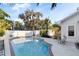 Backyard pool with patio area surrounded by lush landscaping and a white privacy fence at 934 Lake Elbert Se Dr, Winter Haven, FL 33880