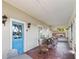 Inviting porch with tile floors, rocking chairs, and a bright blue door at 934 Lake Elbert Se Dr, Winter Haven, FL 33880