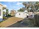 Backyard shed with a white exterior and a door, surrounded by trees and greenery at 934 Lake Elbert Se Dr, Winter Haven, FL 33880