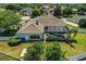 An aerial view of a home with a screened-in pool, well-manicured landscaping, and a fenced yard at 942 Hanover Way, Lakeland, FL 33813