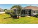 The expansive backyard showcases lush grass, mature trees, and a serene screened-in pool area at 942 Hanover Way, Lakeland, FL 33813