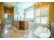 Bathroom features dual showerheads, tub and closet with white cabinets and marble floors at 942 Hanover Way, Lakeland, FL 33813