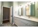 Bright bathroom with double sink vanity, quartz countertop, framed mirrors, and stylish light fixtures at 942 Hanover Way, Lakeland, FL 33813