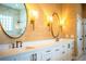 Bathroom with double sinks, custom mirrors, granite counters, and glass shower at 942 Hanover Way, Lakeland, FL 33813