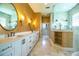 Elegant bathroom features a double vanity, oval mirrors, and marble floors for a luxurious feel at 942 Hanover Way, Lakeland, FL 33813