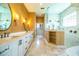 Bathroom with double sinks, custom mirrors, soaking tub, and glass shower at 942 Hanover Way, Lakeland, FL 33813