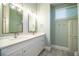 Bathroom featuring a double sink vanity with quartz countertop, framed mirrors, and modern light fixtures at 942 Hanover Way, Lakeland, FL 33813