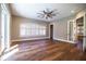 Bright bedroom featuring hardwood floors, modern ceiling fan, and large windows with plantation shutters at 942 Hanover Way, Lakeland, FL 33813