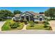 Charming gray home boasts well-maintained landscaping, including topiaries and a lush green lawn at 942 Hanover Way, Lakeland, FL 33813