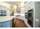 Contemporary kitchen featuring white cabinets, stainless steel appliances and a stone vent hood at 942 Hanover Way, Lakeland, FL 33813