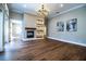 Open living room with fireplace, hardwood floors, and stylish light fixture at 942 Hanover Way, Lakeland, FL 33813