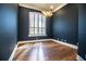 Stylish office featuring hardwood floors, an elegant light fixture, and a large window with plantation shutters at 942 Hanover Way, Lakeland, FL 33813