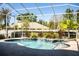 Relaxing screened-in pool area featuring mature landscaping and serene water features at 942 Hanover Way, Lakeland, FL 33813