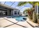 Sparkling pool with sun-shelf, water fountain, and mature landscaping in screened-in patio at 942 Hanover Way, Lakeland, FL 33813
